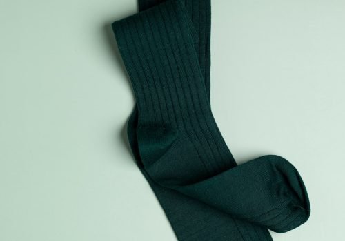 a pair of green socks laying on top of a white surface